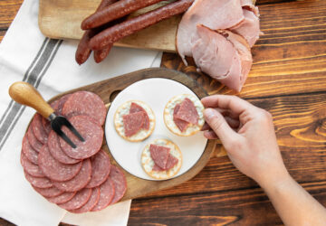Picking up a cracker with summer sausage